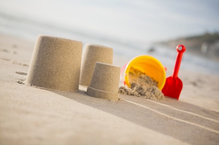 Bucket, spade and sand castles on beach